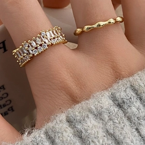 Gold open rings set with sparkling zircon baguettes and textured wave band on hand