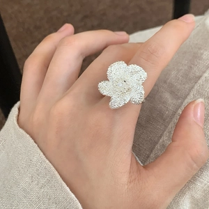 Minimalistischer matter Silber-Blumenring mit Textur am Finger, eleganter Blumenschmuck