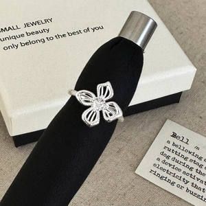 Elegant silver open ring featuring a hollow flower design and a brilliant center stone