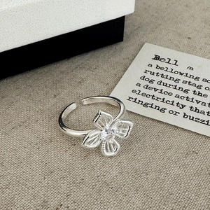 Minimalist silver open ring with hollow flower design and sparkling center zircon