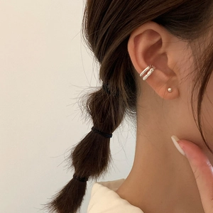 Minimalist silver crisscross ear cuff set with smooth and twisted textures on model
