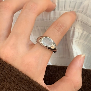Close-up of a vintage silver cat's eye stone open ring worn on a finger
