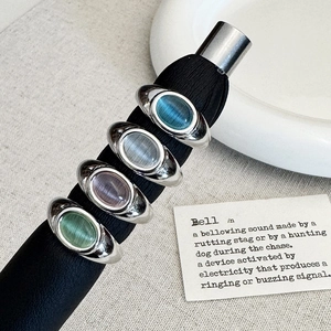 Set of four luxury retro cat's eye rings in multiple colors on a black display stand