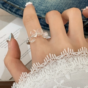 Elegant beaded ring featuring clear multifaceted glass beads worn on the index finger