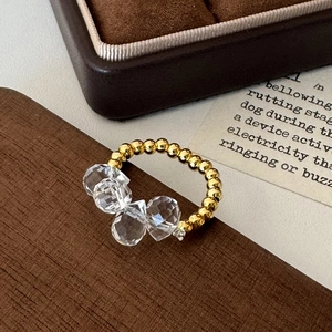 Detailed close-up of elastic beaded ring with gold spheres and faceted glass crystals