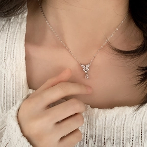 Elegant silver butterfly necklace with teardrop zircon pendant shown on model