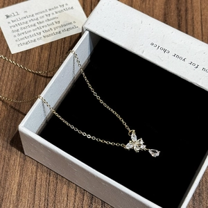 Close-up of gold butterfly necklace with marquise zircons in a premium black jewelry box