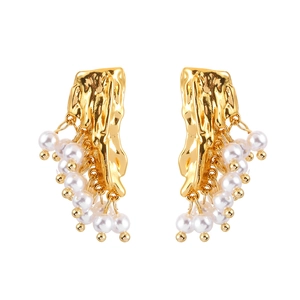 Elegant gold earrings with irregular lava texture and hanging white pearl tassels