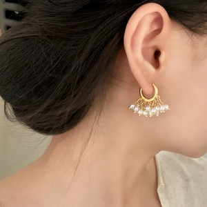 Élégantes créoles dorées de style français avec neuf perles portées par un mannequin
