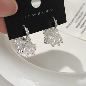 Détail macro de boucles d'oreilles créoles à grappe de perles de style français sur carte