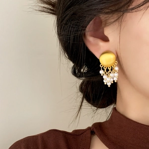 Boucles d'oreilles rétro françaises en or brossé avec pampilles de perles sur un modèle