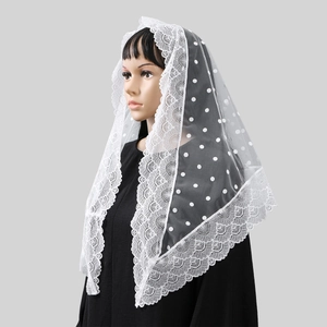Detail of white polka dot lace mantilla veil with floral embroidery on mesh fabric