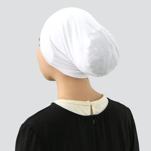 Detail of white cotton under-scarf cap showing smooth back shape and comfortable fit