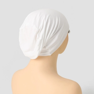 Detail of white mercerized cotton turban cap showing elastic knit texture and breathable fabric
