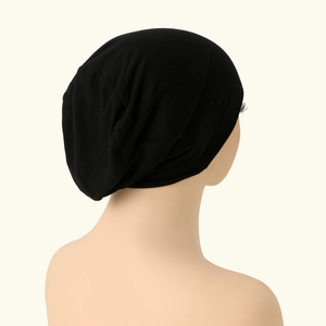 Detail view of the soft black mercerized cotton fabric and drapery of the turban hat