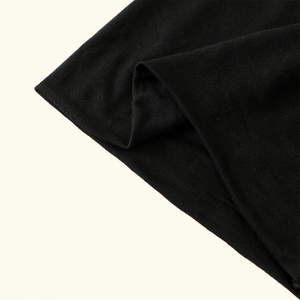 Detailed macro view of black mercerized cotton fabric texture on a flat top turban hat