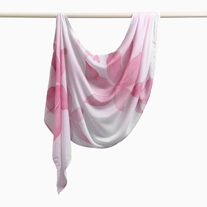 Detail eines Chiffon-Schals mit zartrosa Blumendruck auf weißem Hintergrundgewebe