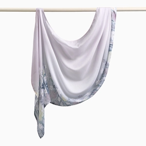 Nahaufnahme eines halbtransparenten lila Blumenschals aus Voile an einer Kleiderstange
