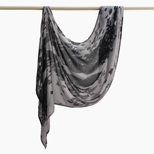 Detail eines hängenden Schals mit schwarz-grauem Blattmuster aus leichtem Chiffonstoff