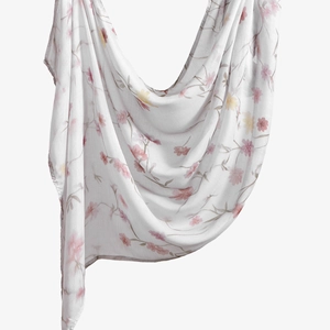 Detail eines leichten weißen Voile-Schals mit zartem rosa und gelbem Blumenmuster