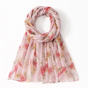 Close-up of lightweight floral voile scarf with soft pink background and red flower prints