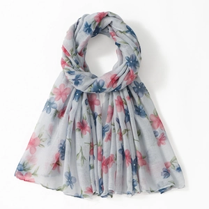 Detailed texture of lightweight voile scarf with floral prints in soft blue and pink