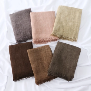 Flat lay of textured pleated hijabs in six earth tones with delicate fringe edges