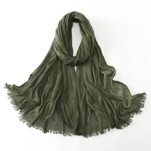 Detailed view of dark green pleated cotton shawl with delicate fringe tassels