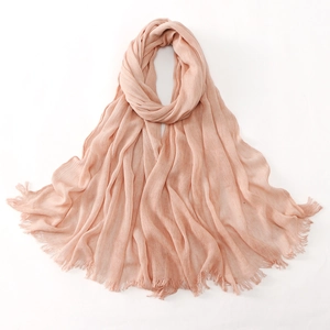 Detail of peach pink textured hijab fabric with pleated wrinkles and fringe edges