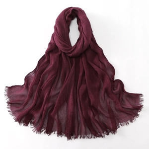 Detailed view of dark wine red hijab fabric with soft crinkle texture and frayed edges