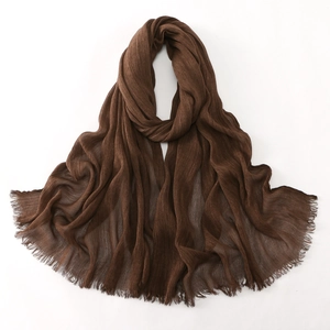 Close-up of deep brown crinkled cotton shawl with frayed edges and lightweight texture