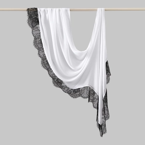 Detail of white chiffon scarf with elegant black eyelash lace trim on a wooden hanger