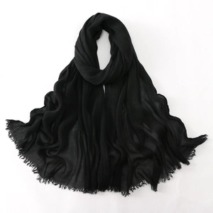 Macro shot of black crinkle viscose scarf showing textured fabric and frayed fringe edges