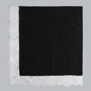 Detail of elegant black long scarf with delicate white floral eyelash lace trim