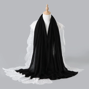 Detail of black hijab scarf featuring elegant white lace embroidery on edges