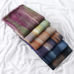 Detail of colorful gradient pleated scarves with fringe trim and soft woven texture