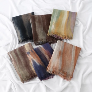 Close-up of assorted rectangle scarves with fringe details and gradient color patterns