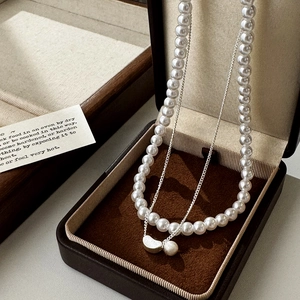 Detail of elegant double-layer pearl necklace with silver crescent moon pendant in a gift box