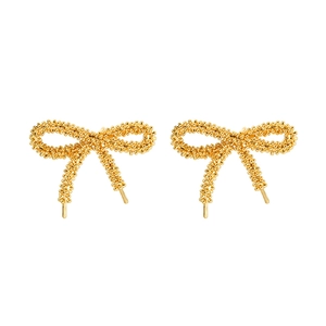 Golden bow stud earrings with textured silver grain finish in a minimalist luxury style