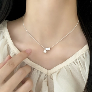Elegant double-layer silver chain necklace with pearl and bean pendant on female model