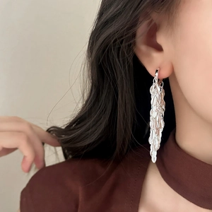 Boucles d'oreilles longues à pampilles en feuille d'argent portées par un mannequin