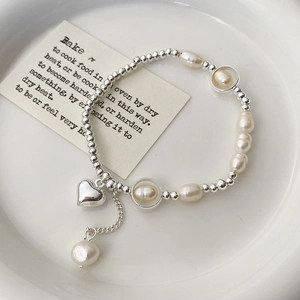 Detail of freshwater pearl bracelet with silver heart charm and irregular beads