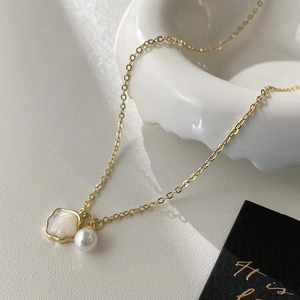 Collier en chaîne dorée élégante avec un pendentif en nacre et une perle blanche