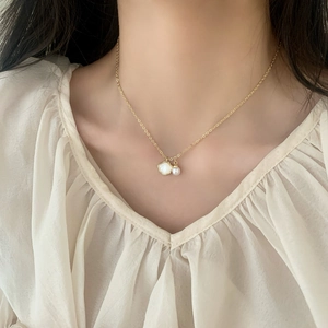 Collier élégant en chaîne dorée avec pendentif coquillage blanc et perle sur un modèle