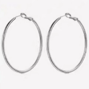 Close-up of large silver geometric hoop earrings with polished thin tube and clasp