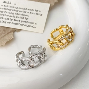 Verstellbare kubanische Gliederringe in Gold und Silber mit Zirkonsteinen auf Keramikteller