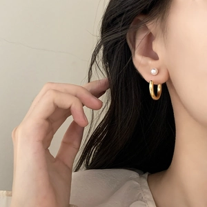 Ensemble créoles dorées et boucles d'oreilles perles blanches portées par un modèle