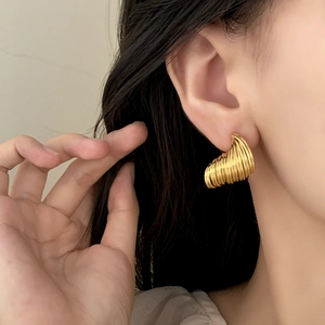 Chic gold-toned spiral geometric earrings featuring layered metallic textured design