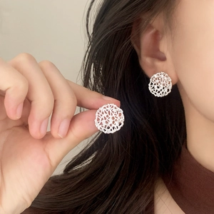 Elegant hollow silver disc earrings with intricate lace texture and sparkling zirconia studs