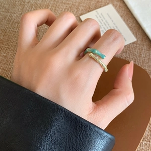 Detail of bamboo joint ring featuring emerald green enamel and paved zircons on model
